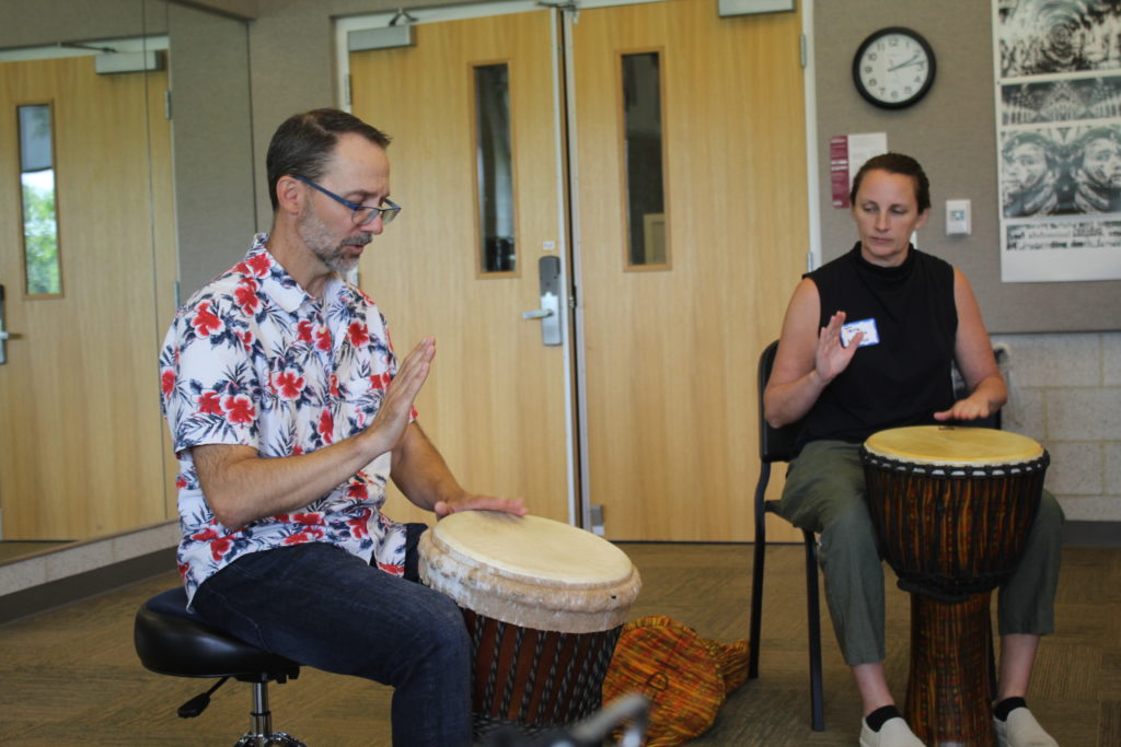 Faculty members play drums at recent all faculty retreat 