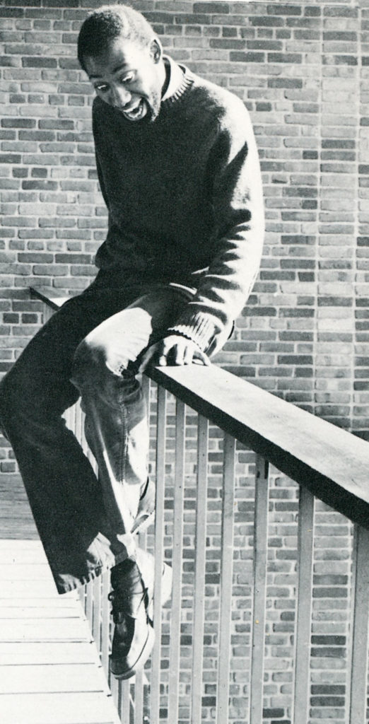 Earlham student sits on railing 