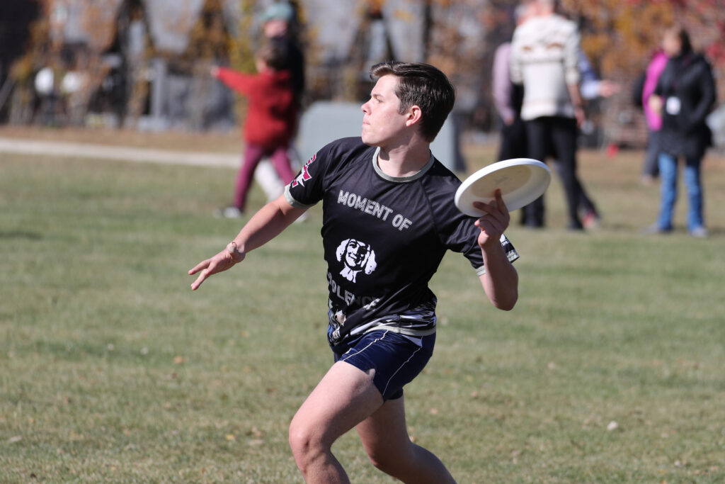 An Earlham student throws a frisbee during the alumni Ultimate Frisbee game. 