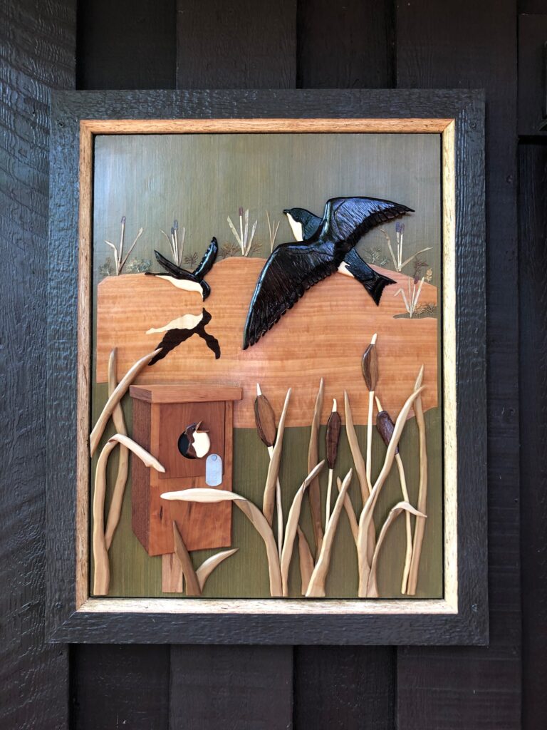 Artwork featuring three swallows and a birdhouse with a baby bird.