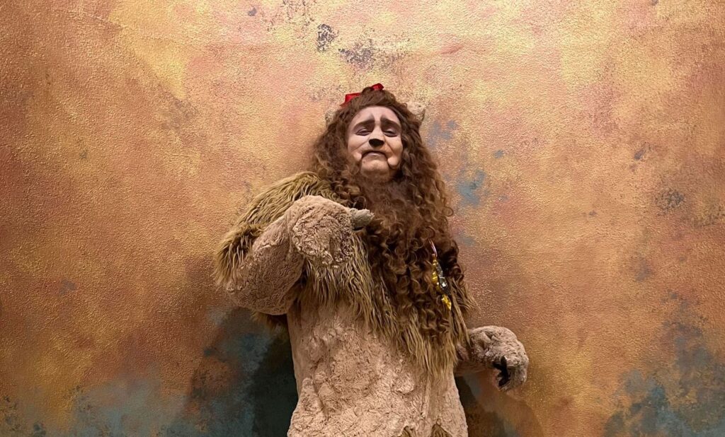 Earlham alum Jordan Wolfe poses as The Cowardly Lion from the Wizard of Oz.